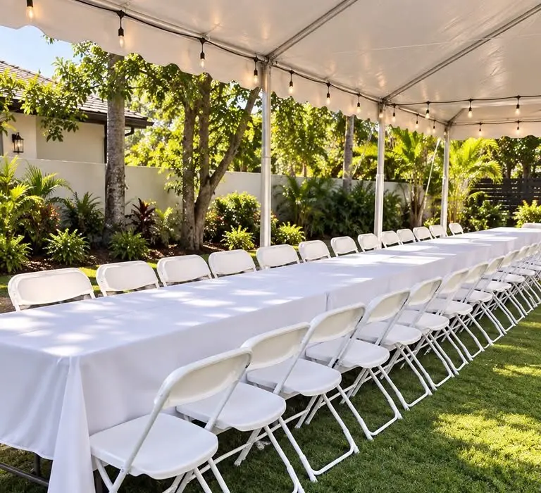 Mesas largas con manteles blancos bajo una carpa